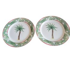 two plates with palm trees on them are shown against a white background, one is green and the other is red