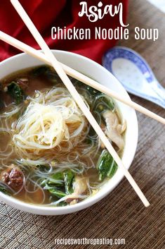 a white bowl filled with noodles and meat on top of a table next to chopsticks