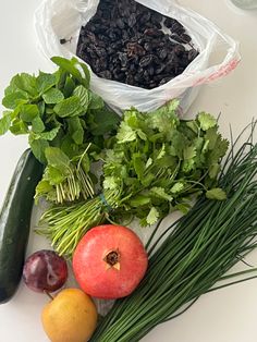 vegetables and fruits are sitting on a white counter top next to a bag of seeds