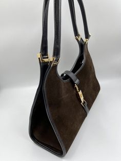 A stunning vintage Gucci Jackie bag made from brown suede, black leather with gold hardware. Inside the bag is lined with a very special gold nylon lining and there is a zipped pocket for valuables. This bag is in very good vintage condition. There are some slight marks to the suede and minor wear to be seen on the gold hardware. A true collectors item, increasingly hard to find the vintage Jackie bag's with gold hardware. This bag also comes with its original Gucci dust bag. Vintage Gucci Jackie, Gucci Collection, Brown Suede, Gucci Jackie Bag, Vintage Gucci, Gold Hardware, Fashion Bags