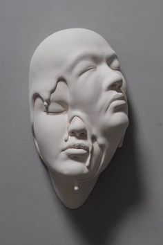 a white mask with the face of a man's head cut out to look like he is sleeping