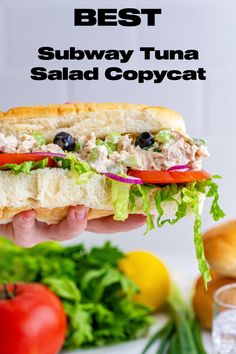 A Subway Tuna Salad Sandwich Copycat being held in the air above a tomato, some lettuce and onions. Copycat Kmart Sub, Subway Copycat Recipes Sandwiches, Best Tuna Salad Recipe Sandwiches, Copycat Subway Tuna, Tuna Salad Croissant Sandwich, Subway Tuna Recipe, Subway Tuna Sandwich, Simple Tuna Recipes, The Best Tuna Salad Recipe