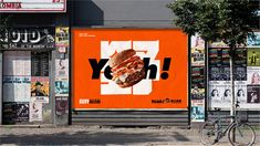 an advertisement on the side of a building with a large sandwich in front of it