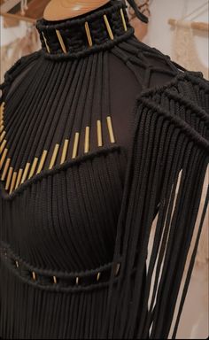 a mannequin with black and gold fringes on it's neckline