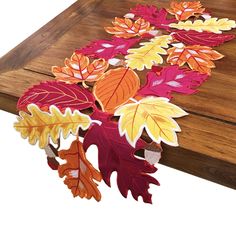 a wooden table topped with lots of colorful leaves