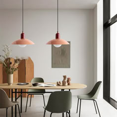 a dining table with four chairs and two pendant lights hanging from it's ceiling