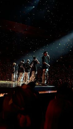 a group of people standing on top of a stage in front of a large crowd