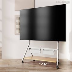 a large screen mounted to the side of a wall in a room with wooden flooring