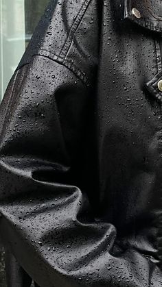 a man in a black leather jacket is holding an umbrella