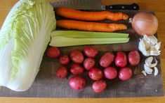 some vegetables are laying on a cutting board next to an onion, carrots and celery