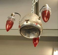 an old fashioned light fixture hanging from a metal chain with two red lights attached to it