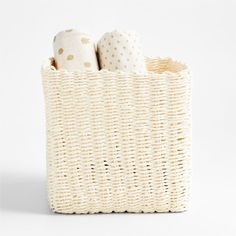 a wicker basket with three rolls of toilet paper in it on a white background