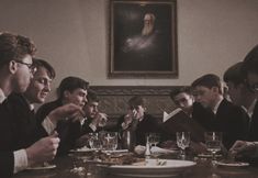 a group of young men sitting around a wooden table