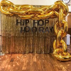 a large gold chain is in front of a backdrop that says hip hop today