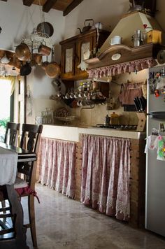 an old fashioned kitchen with lots of pots and pans hanging from the ceiling