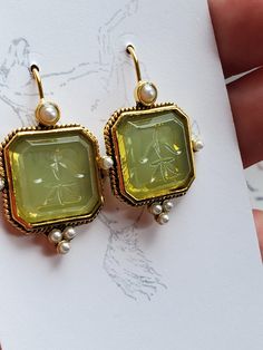 I saw these earrings and knew they were perfect to offer in the shop.  They are gold plated earwires with a square glass green intaglio and pearl elements.  Perfect to wear for late 18th century, early 19th century on up to today.  I love them! They measure 1-1/4 inches long by just over 1/2 inch wide.  The earwire is super long which is good to stay in the ear. Lots of inspiration on my Pinterest page.  https://www.pinterest.com/kkwalte/_saved/ Victorian Intaglio Earrings For Wedding, Vintage Intaglio Earrings For Wedding, Vintage Rectangular Intaglio Jewelry, Elegant Nickel-free Rectangular Jewelry, Intaglio Drop Earrings For Gift, Ornate Gold Rectangular Jewelry, Ornate Rectangular Gold Jewelry, Elegant Green Rectangular Earrings, Elegant Yellow Rectangular Earrings