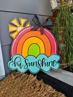 a wooden sign that says sunshine with a rainbow in the center and sun above it