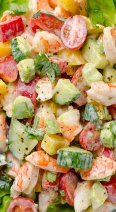 a salad with shrimp, cucumber, tomatoes and lettuce in it