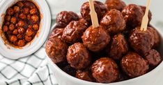 some meatballs are in a white bowl with toothpicks