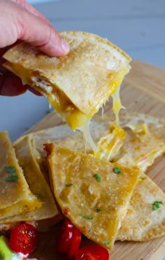 someone is dipping cheese on top of tortilla chips