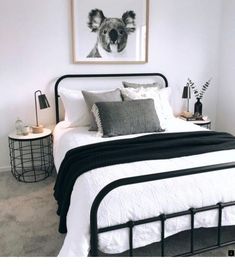 a bedroom with a bed, nightstands and pictures on the wall above it in black and white