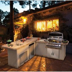 an outdoor kitchen with grill and sink at night