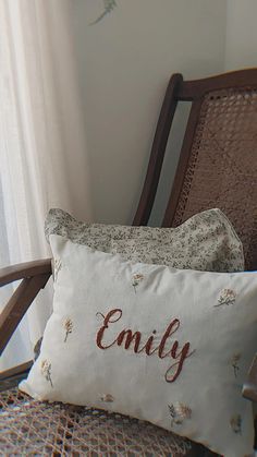 two pillows sitting on top of a chair next to a window