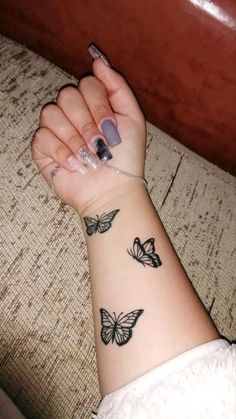 a woman's arm with butterfly tattoos on it