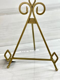 a gold metal stand with an open triangle on it's top and two small circles at the bottom