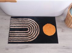 a bathroom rug with an orange circle on the floor next to a bathtub and toilet