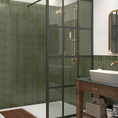 a green tiled bathroom with a sink, shower and stand up shower stall in the corner