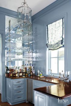 a kitchen filled with lots of bottles and glasses on top of a wooden countertop