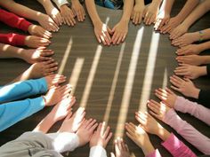 a group of people standing in a circle with their hands together