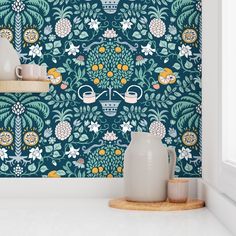 a blue wallpaper with flowers and plants on it, next to two vases