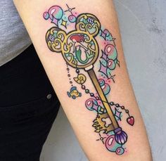 a woman's arm with a tattoo on it that has an ornate key and hearts