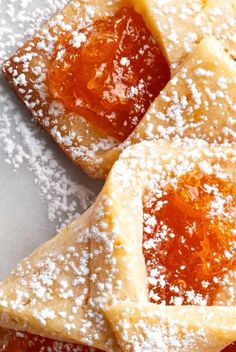 three pieces of pastry with powdered sugar on top