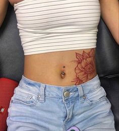 a woman's stomach with a flower tattoo on her lower body and bottom part