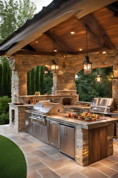 an outdoor kitchen with grills and lights