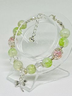 This enchanting bracelet captures the essence of summer with its light green beads that shimmer in the sunlight. Adorned with a delicate dragonfly charm, it adds a touch of whimsy and nature-inspired elegance to any outfit. Perfect for those who appreciate the beauty of summer and the serenity of dragonflies. Dragonfly Charm, Green Beads, Summer Breeze, Green Bead, Dragonflies, Adjustable Bracelet, Nature Inspired, Light Green, Nature Inspiration