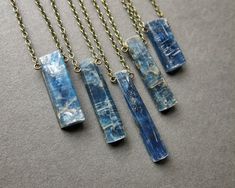 Imperial Kyanite Necklace: Carry a piece of the earth's beauty with you wherever you go! This striking crystal pendant is the perfect gift for yourself or your favorite crystal lover! ✧ Hand selected imperial kyanite ✧ Natural semi-polished crystal, NOT treated or dyed ✧ Crystal size 12-30mm long (mini and small crystals are smaller than the ones shown in the other photos) ✧ Select your favorite crystal from the dropdown menu ✧ Antique brass chain in your chosen length ✧ Hypoallergenic metals up Witchy Boho, Kyanite Necklace, Kyanite Jewelry, Green Kyanite, Pebble Necklace, Raw Stone Necklace, Blue Crystal Necklace, Raw Crystal Necklace, Boulder Co