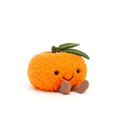 an orange stuffed animal sitting on top of a white floor next to a green leaf