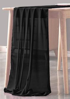 a black curtain hanging from the side of a wooden table