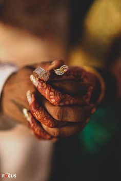 the bride and groom are holding their wedding rings