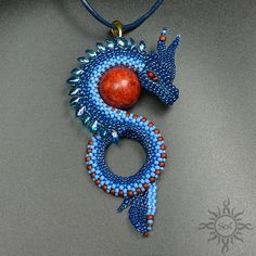 a blue and red beaded dragon pendant on a leather cord