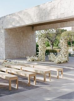 a row of wooden benches sitting next to each other on top of a cement floor