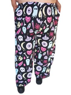 See MORE clothing at shopsoftcore.com Frightfully cute characters dance across these pants! These comfortable wide legged pants are the perfect base for a bold streetwear look or for lounging at home. With the adjustable waist and stretchy fabric, putting an outfit together is easier than ever! * 100% original softcore design, made sweatshop free! * This item comes in sizes 2XS - 6XL * Made from premium knit mid-weight jersey fabric, soft to the touch and stretchy. * Relaxed unisex fit, meant to be worn slightly oversized. * Practical side pockets! * Elastic waistband with a white drawstring so you can easily adjust the waist. * Can be worn on the waist or on the hips. Our first model is wearing a size 5XL. Our model with red hair is wearing a size 2XL. They are 5' 3" in height with a 43" Stretch Bottoms For Halloween Cosplay, Emo Style Pants For Halloween Streetwear, Cute Black Loungewear Bottoms, Halloween Stretch Emo Bottoms, Harajuku Style Halloween Cosplay Bottoms, Harajuku Style Bottoms For Halloween Cosplay, Emo Cotton Bottoms For Halloween, Halloween Emo Style Cotton Bottoms, Halloween Emo Cotton Bottoms