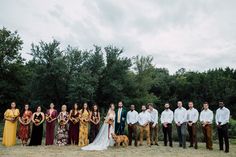 a group of people standing next to each other in front of some trees and bushes