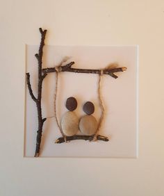 two rocks sitting on top of a branch in the shape of a square with branches