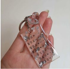 a person is holding a key chain in their left hand and wearing a clear plastic case with silver stars on it