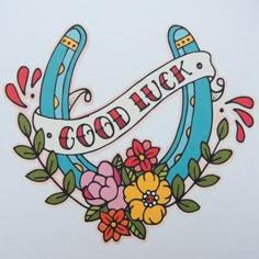 a sticker that says good luck with flowers and ribbons on it's side